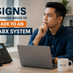 5 Signs Your Business Needs to Upgrade to an IP PABX System Business professional in an office reviewing communication needs beside an IP phone and laptop, illustrating the article "5 Signs Your Business Needs to Upgrade to an IP PABX System." The image highlights modern business communication, customer service, and phone system upgrades.